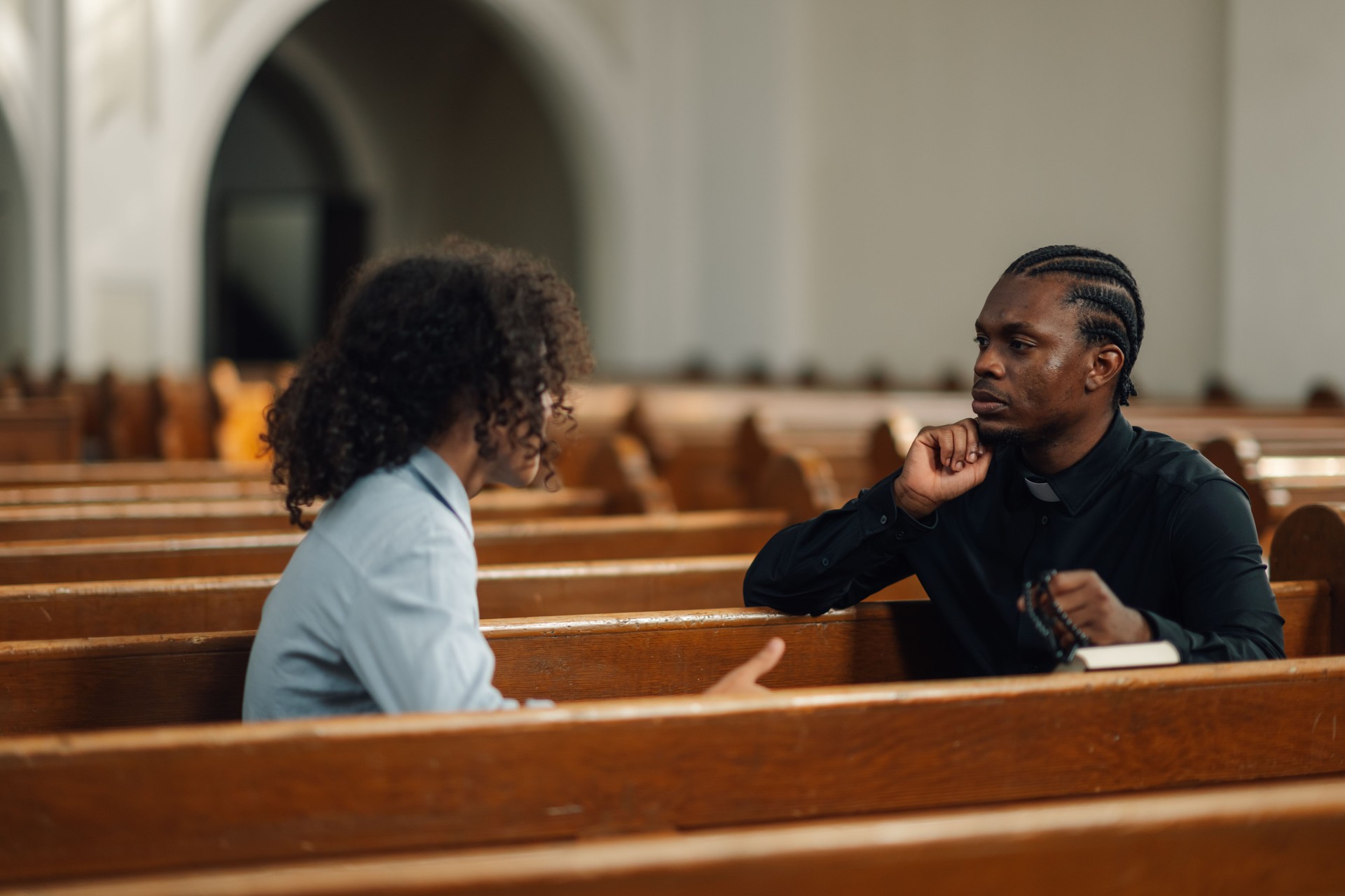 Priest listening to young man talking about problems in church